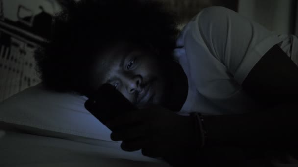 Gros plan de l'homme africain utilisant le téléphone dans le lit — Video