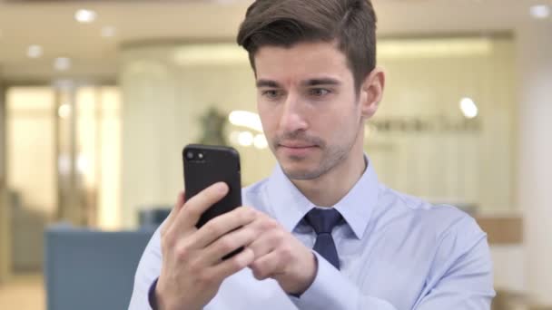 Бизнесмен в шоке при использовании смартфона — стоковое видео