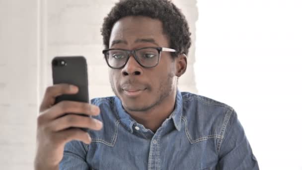 Afrikansk man med hjälp av smartphone, textmeddelanden — Stockvideo