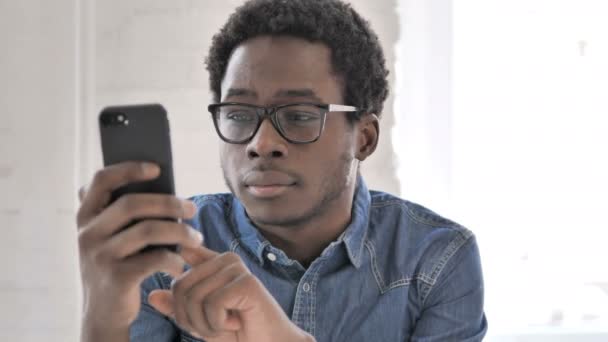 African Man Busy Text Messaging on Smartphone — Stock Video