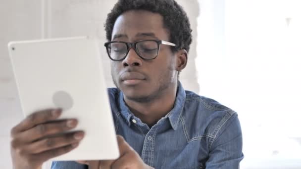Δημιουργικός Αφρικανός άνθρωπος περιήγηση στο διαδίκτυο στο tablet — Αρχείο Βίντεο
