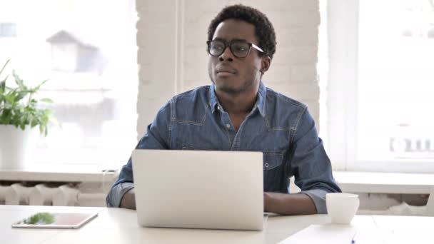 Συλλογισμένος αφρικανική άνθρωπος σκέφτεται και λειτουργεί σε φορητό υπολογιστή — Αρχείο Βίντεο