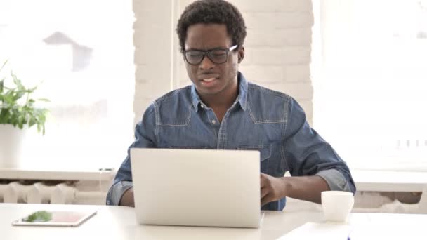 Hombre africano con dolor de espalda trabajando en el ordenador portátil — Vídeos de Stock