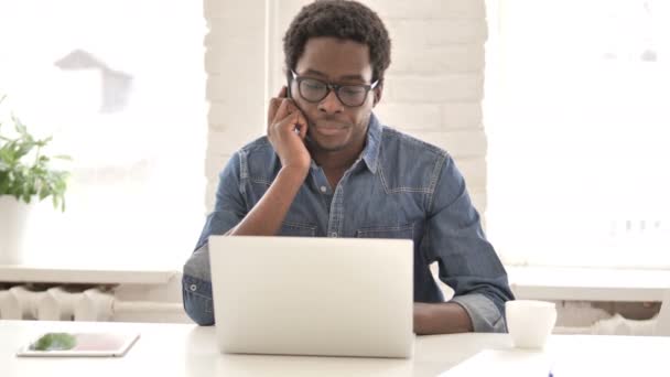 African Man Talking on Phone at Work — Stock Video