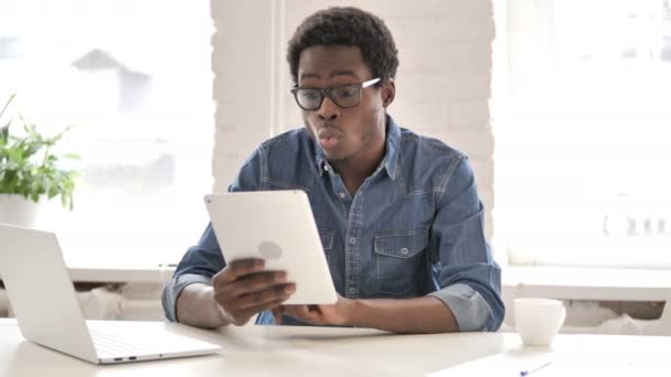 Африканський чоловік святкує успіх під час використання планшета — стокове відео