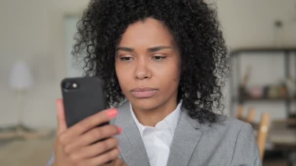 Afrikanische Geschäftsfrau reagiert auf Verlust mit Smartphone — Stockvideo