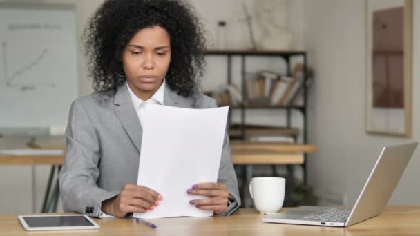 Upphetsad afrikansk affärskvinna jublande medan du läser dokument på jobbet — Stockvideo