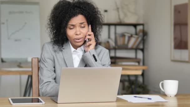 Empresaria africana hablando por teléfono en el trabajo — Vídeo de stock