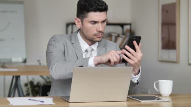 Empresario usando smartphone y laptop — Vídeos de Stock