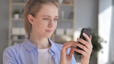Akıllı telefon kullanan genç bir kadın.