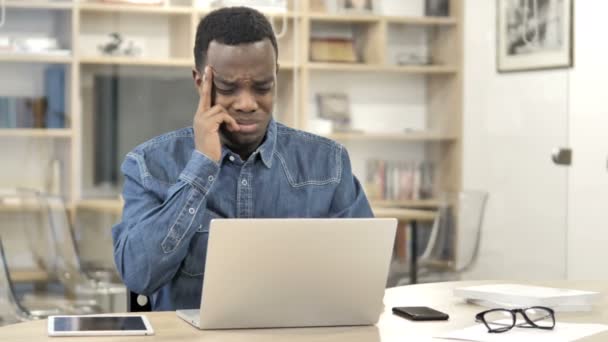Dolor de cabeza, hombre africano cansado trabajando en el ordenador portátil — Vídeo de stock