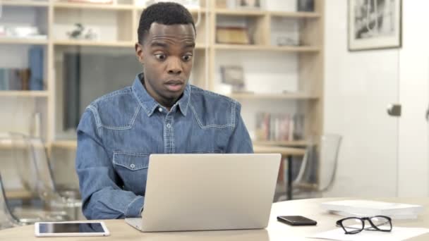 Schrecklicher Afrikaner unter Schock, der am Laptop arbeitet — Stockvideo