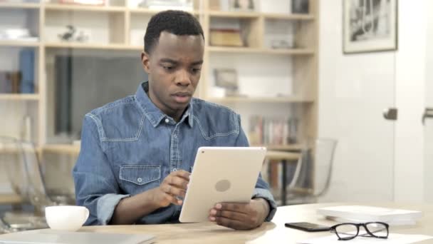 Hombre africano reaccionando a la pérdida mientras usa la tableta — Vídeo de stock