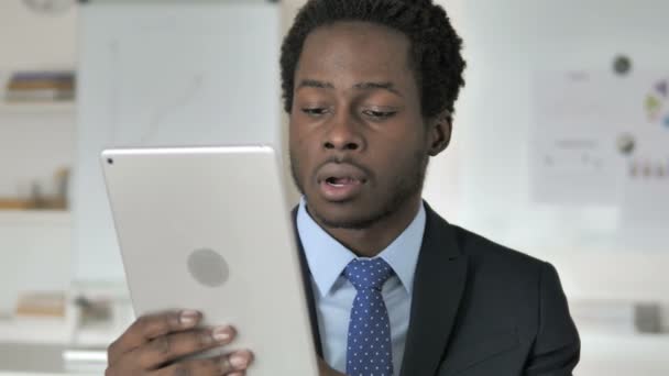 Africký podnikatel oslavující online úspěch na tabletu — Stock video