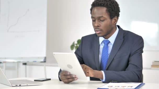 Empresario africano reaccionando a la pérdida financiera en la tableta — Vídeos de Stock