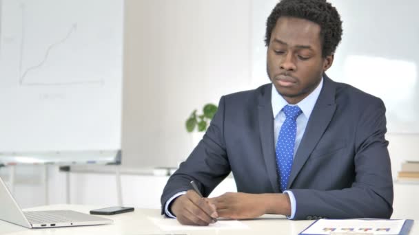 Afrikaanse zakenman schrijven brief in Office — Stockvideo