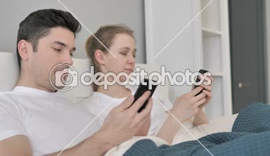 Çift yatakta Smartphone kullanarak