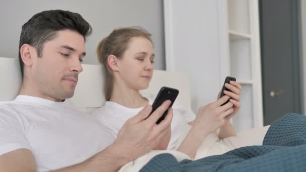 Para przy użyciu smartfona w łóżku — Wideo stockowe