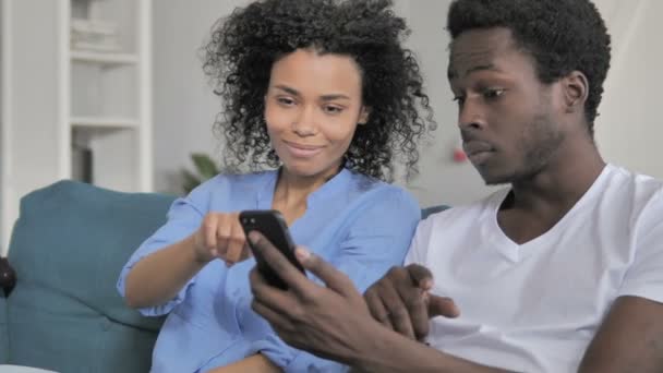 African Couple Celebrating Success on Smartphone — Stock Video