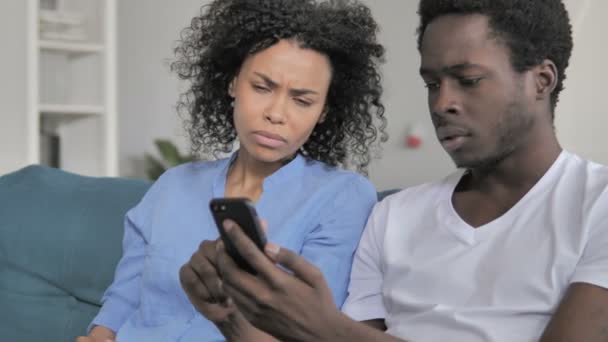 Afrykańska para reaguje na utratę na smartfonie — Wideo stockowe
