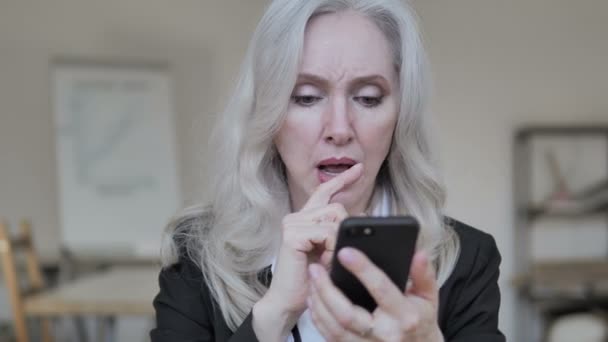 Alte Geschäftsfrau verärgert über Verlust am Smartphone — Stockvideo