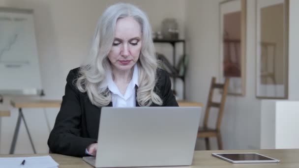 Старшая предпринимательница, работающая над ноутбуком — стоковое видео