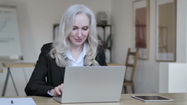 Старшая предпринимательница празднует успех на ноутбуке — стоковое видео