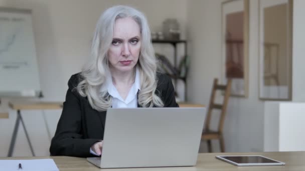 Старшая предпринимательница мыслит и работает над ноутбуком — стоковое видео