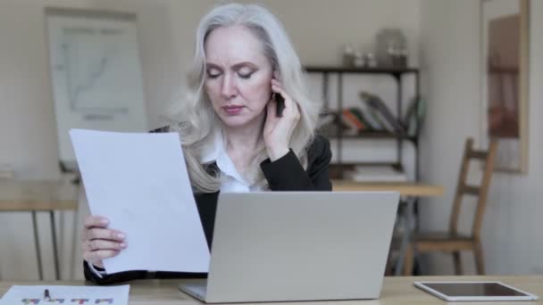 Старая деловая женщина читает документы — стоковое видео