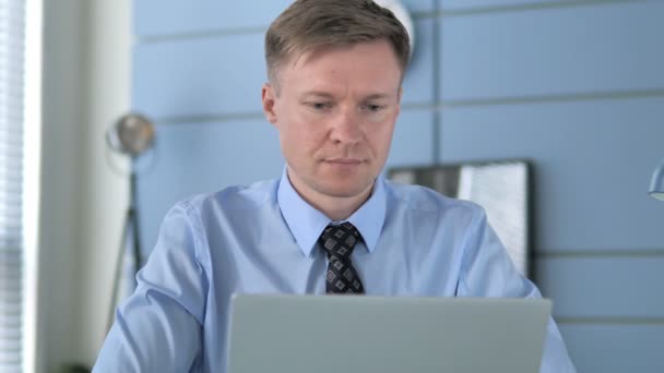 Lächelnder Geschäftsmann im Büro blickt in die Kamera — Stockvideo