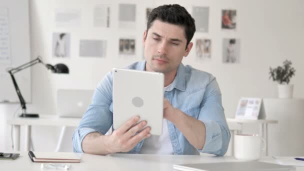 Nenucený mladý muž používající tablet v kanceláři — Stock video