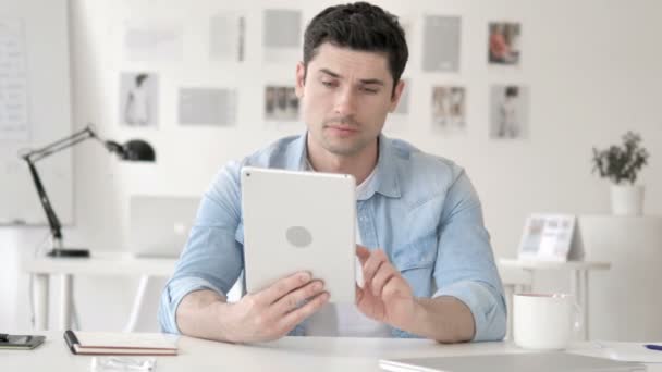 Hombre joven casual en shock mientras usa la tableta — Vídeos de Stock