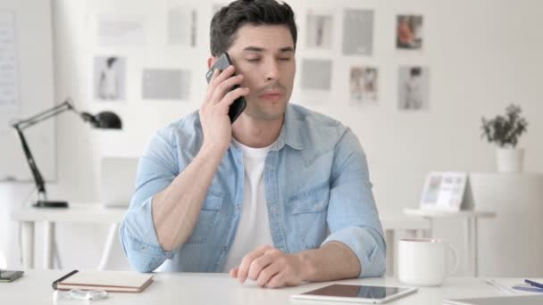 Casual młody człowiek rozmawia na telefon w pracy — Wideo stockowe