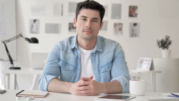 Bem sucedido Sorrindo Casual Jovem Sentado no Local de Trabalho — Vídeo de Stock