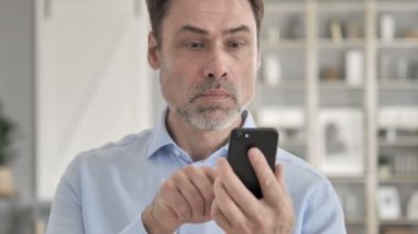 Yaşlı İşadamı Akıllı Telefonda Başarıyı Kutluyor