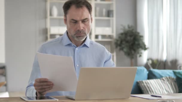 Alter Geschäftsmann arbeitet an Dokumenten und Laptop — Stockvideo