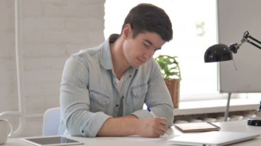 genç adam kağıda yazı