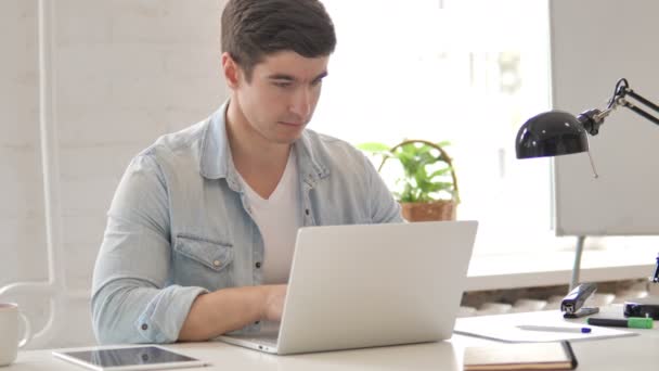 Молодой человек работает на ноутбуке — стоковое видео
