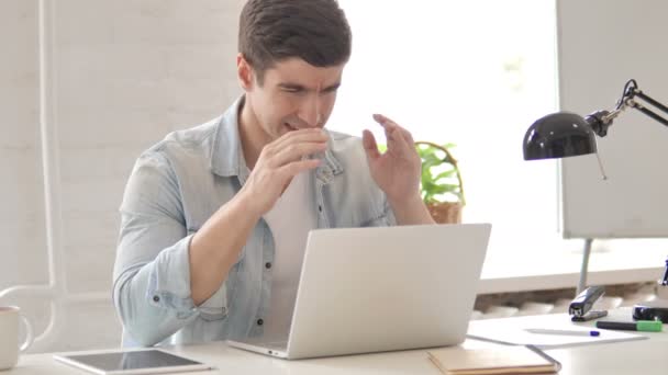 Gestresster junger Mann mit Kopfschmerzen arbeitet am Laptop — Stockvideo