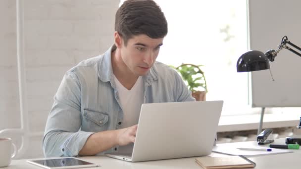 Młody człowiek świętuje sukces projektu na laptopie — Wideo stockowe
