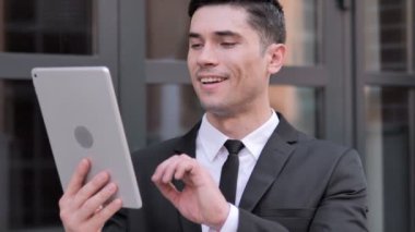 Tablet ile Genç İşadamı tarafından Outdoor Görüntülü Sohbet
