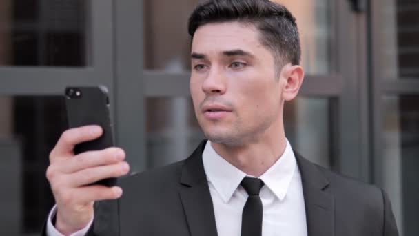 Открытый бизнесмен празднует успех на смартфоне — стоковое видео