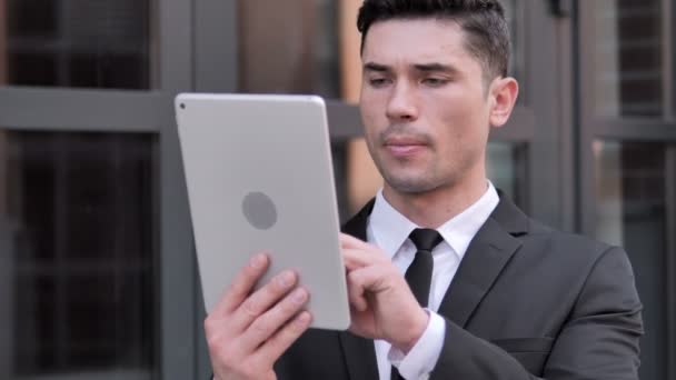 Реакция бизнесмена на потерю на планшете, на открытом воздухе — стоковое видео