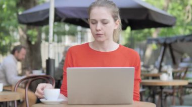 Cafe Terrace'ta Dizüstü Bilgisayar da Çalışan ve Kahve İçen Genç Kadın