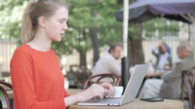 Cafe Terrace Oturan Laptop Kullanarak Baş Ağrısı olan Genç Kadın
