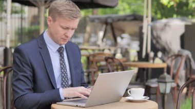 Pensive İşadamı Outdoor Cafe Laptop üzerinde çalışıyor