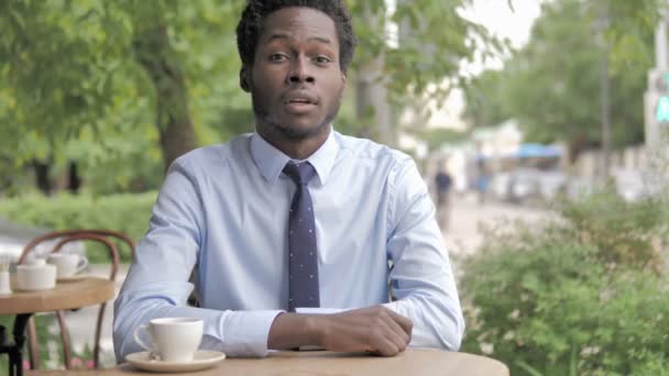 Да, принятие африканского бизнесмена, сидящего в открытом кафе — стоковое видео
