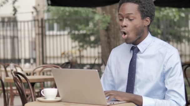 屋外カフェでラップトップで祝うアフリカのビジネスマン — ストック動画