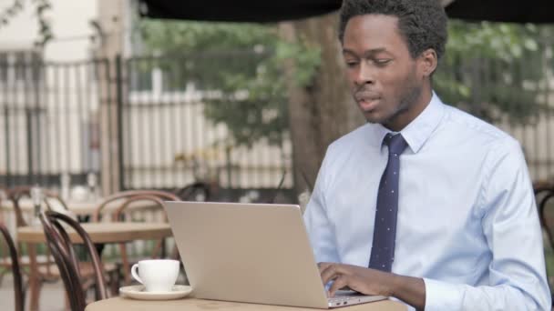Africký podnikatel s bolestí v krku použití notebooku venku — Stock video