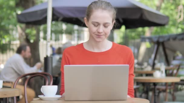 Mujer joven con dolor de cuello usando computadora portátil en Café Terraza — Vídeos de Stock